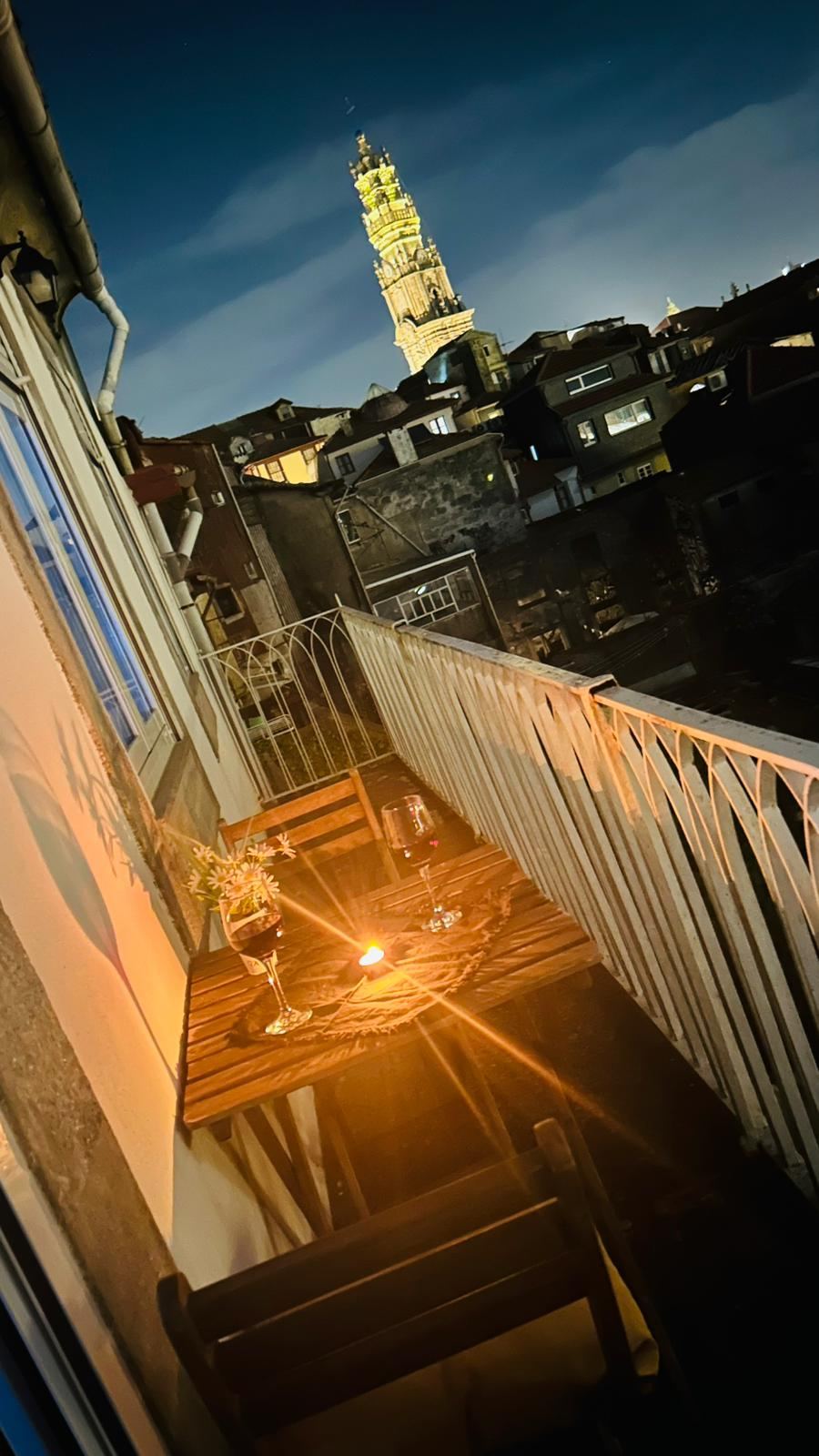 A glass of wine by candlelight on the balcony, Torre dos Clérigos in the background