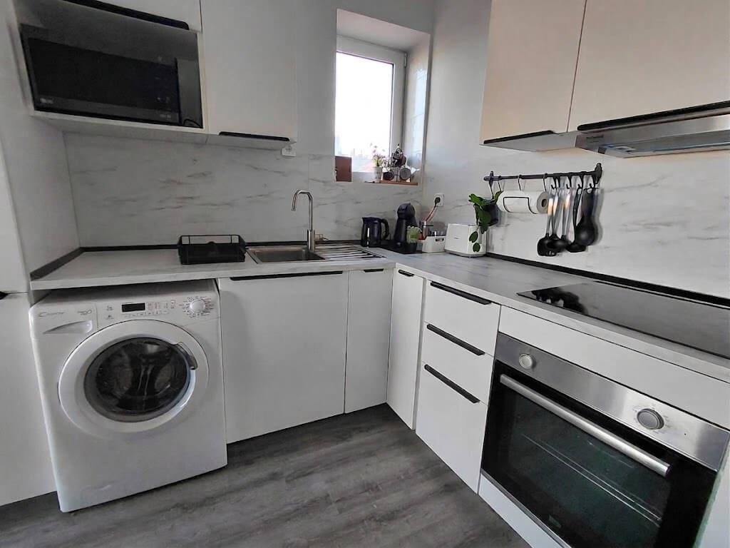 Fully equipped open-space kitchen with marble countertop and dining area, Porto Skyline Residence